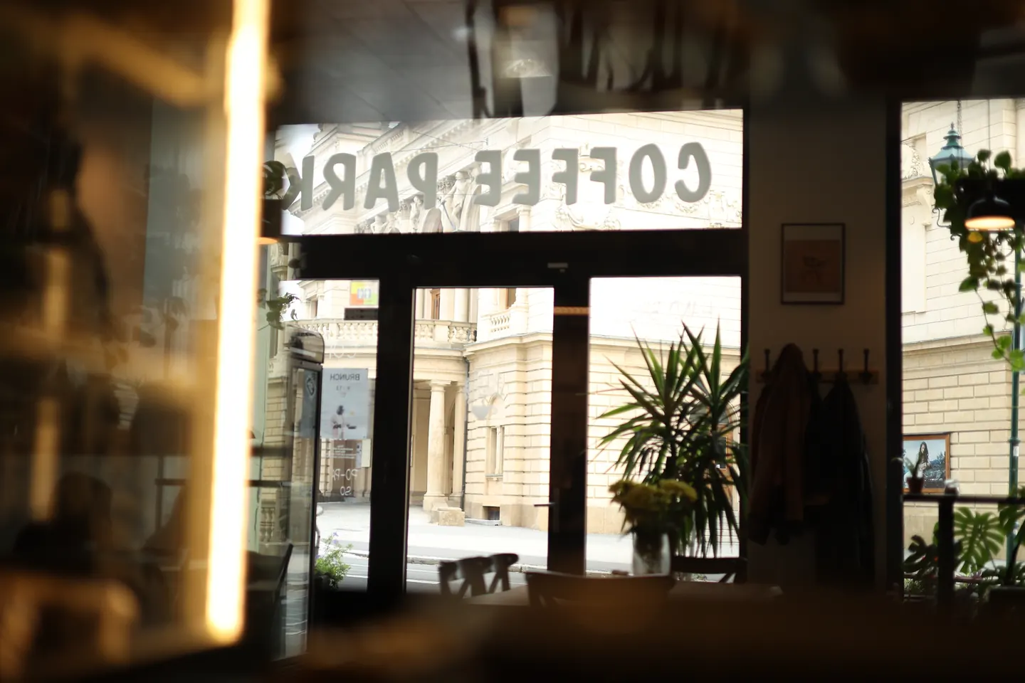 Vchod do Coffee Park, za oknem budova Divadla J. K. Tyla