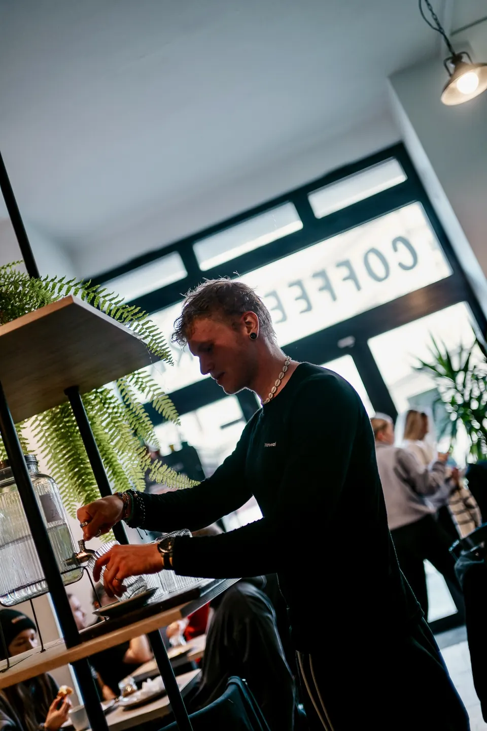 Barista připravuje kávu u okna